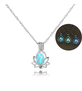 Détail macro du pendentif lotus ajouré avec perle lumineuse bleu glacé sur chaîne argentée
