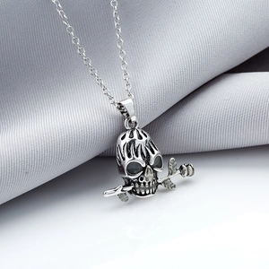 Detailed view of an antique silver skull with rose pendant on a stainless steel chain
