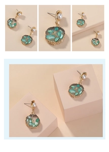 Macro detail van vintage gouden oorbellen met groene stenen en witte parels