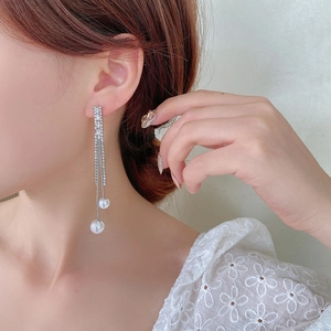 Detailed close-up of long tassel butterfly earrings with crystals and white pearls