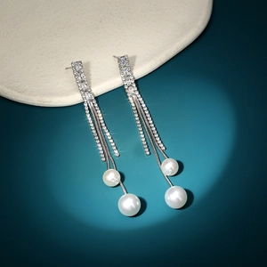 Detail of silver long tassel earrings with baguette rhinestones and white pearls