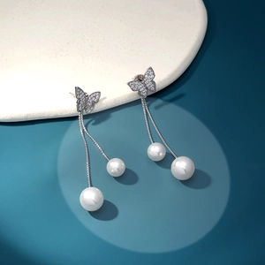 Detail of butterfly drop earrings with shimmering crystals and long pearl tassels