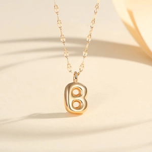 Detail of 18K gold-plated bubble letter B pendant on a delicate link chain necklace