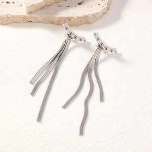 Close-up of silver tassel earrings with rectangular zircons and sleek snake chains