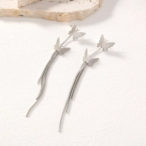 Detailed close-up of elegant silver butterfly tassel earrings with snake bone chains