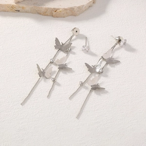 Detail of silver butterfly tassel earrings with cubic zirconia and long chain fringes