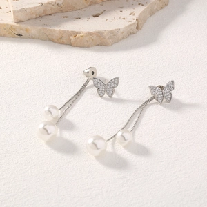 Detailed shot of long butterfly tassel earrings with silver finish and white pearls