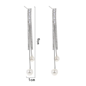 Detail showing long silver tassel earrings with rectangular zircons and white pearls