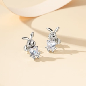 Detalle de pendientes de conejo con circonita en forma de corazón y acabado de plata