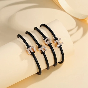 Braided leather bracelets with gold letter charms E F G H and sparkling crystal inlays