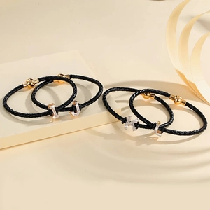 Braided black leather bracelet with gold magnetic clasp and rhinestone letter pendants
