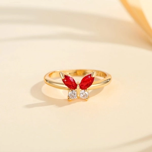 Nahaufnahme des goldenen Schmetterlingsrings mit roten und weißen Zirkonia-Steinen