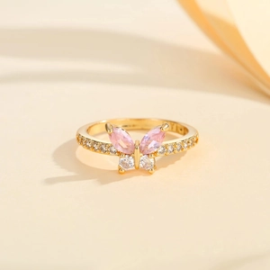 Macro shot of gold butterfly ring with pink marquise stones and crystal accents