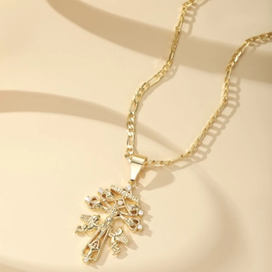 Gold Caravaca cross pendant necklace with white zircons on a classic Figaro chain