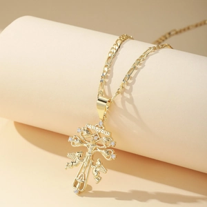 Gold Caravaca cross pendant with clear zircons on a stylish Figaro chain necklace