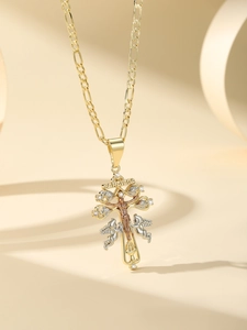 Close-up of golden Caravaca cross pendant with angels and sparkling white zircon stones