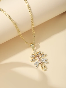 Macro view of tricolor gold Caravaca cross pendant with angel relief and Figaro chain