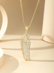 Detailed close-up of a gold St. Jude pendant with micro-pave zircons and Figaro chain