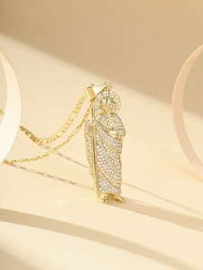 Detail of gold St. Jude religious pendant necklace with zircon stones and Figaro chain