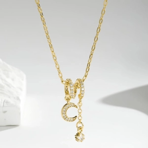 Vista de detalle del collar chapado en oro con colgante de luna y circonitas brillantes
