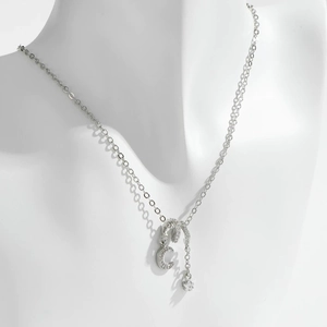 Elegante collar de plata con colgante de luna y estrella de circonitas en un maniquí