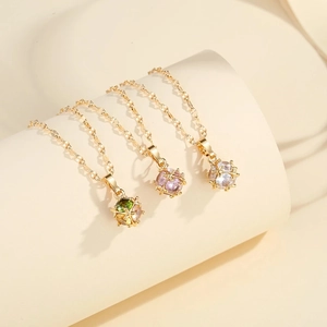 Collier à pendentif boule plaqué or avec cristaux verts violets et blancs sur socle
