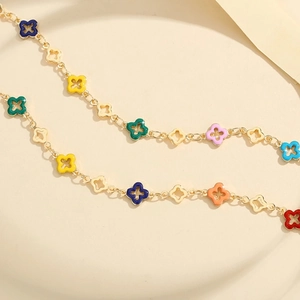 Golden clover necklace featuring colorful enamel flower petals and hollow metal charms