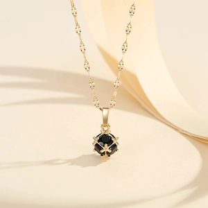 Collier élégant plaqué or avec pendentif boule, pierre noire et cage géométrique ajourée