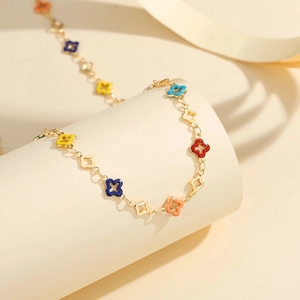 Detail of gold chain necklace featuring multi-colored enamel four-leaf clover charms