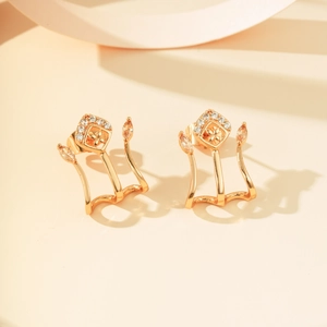 Detail van gouden oorbellen met micro-pave zirkonia en marquise-vormige gele steentjes