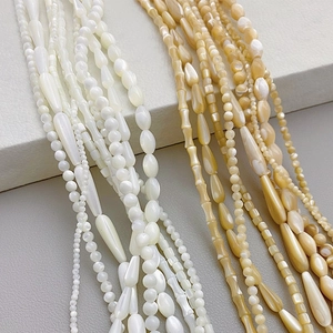 Macro shot of natural shell beads in various shapes like water drop and bamboo for DIY jewelry