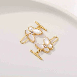 Détail du fermoir papillon OT en or 18K avec nacre blanche sur un plateau blanc
