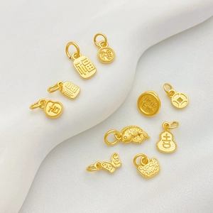 Macrodetail van matgouden bedeltjes met traditionele geluks- en koi-vissen patronen