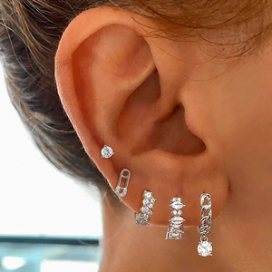 Dettaglio di orecchini e clip in argento con zirconi indossati per uno stile raffinato