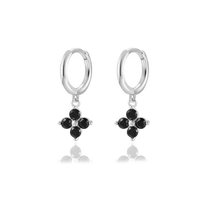 Macro detail of silver hoop earrings with four-leaf clover black zircon stone charms