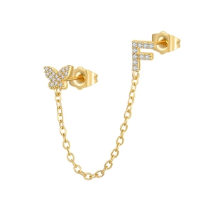 Macro detail of gold-plated butterfly and letter F stud earring with zircon chain