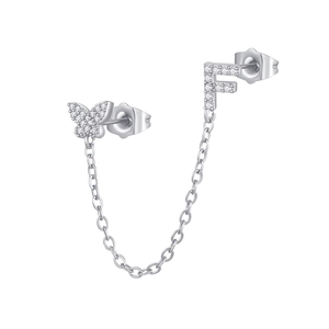 Close-up of zircon butterfly and letter F stud earring connected by a fine silver chain