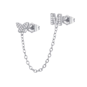Detailed macro view of zircon butterfly and letter M stud earring with thin chain