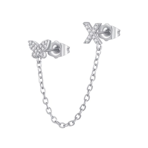 Macro detail of silver tone zircon butterfly and letter X chain earring on white background