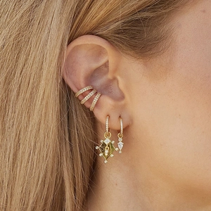 Minimalistische Goldohrringe mit Zirkonia-Steinen, am Ohr eines Models präsentiert