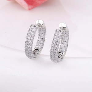 Macro shot of silver hoop earrings with three rows of pave-set cubic zirconia stones