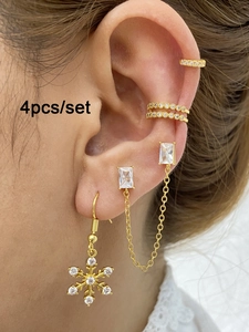 Detailansicht eines 4-teiligen goldenen Ohrring-Sets mit Schneeflocke und Gliederkette