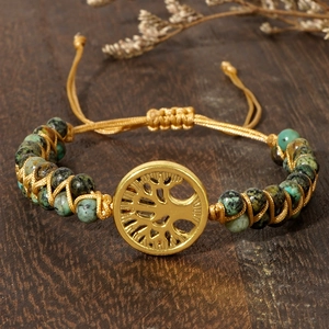 Close-up of handmade Tree of Life bracelet with turquoise beads and golden metal charm