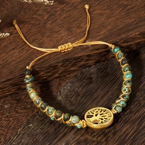Hand-woven African turquoise bead bracelet with a gold Tree of Life pendant detail