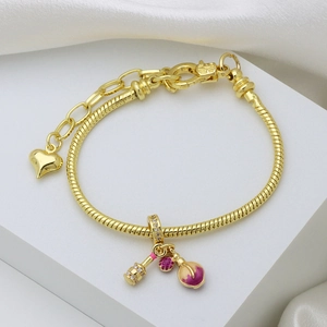 Bracelet chaîne serpent dorée avec breloques en cœur et émail sur fond blanc élégant