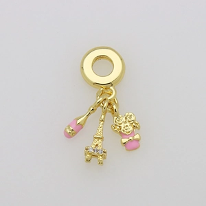 Détail du pendentif tour Eiffel dorée avec breloques champagne rose et boîte cadeau