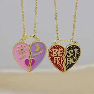Close-up of magnet heart necklaces with sun and moon enamel patterns and gold ball chains