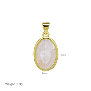 Macro shot of gold oval shell pendant with heart sunray engraving measuring 24x12mm