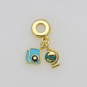 Detailed macro view of gold-plated camera and globe enamel charms on a jewelry pendant