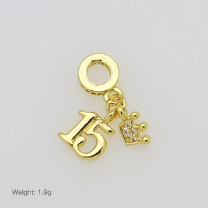 Detailed view of golden number 15 and crown charm with zircon stones, weighing 1.9g